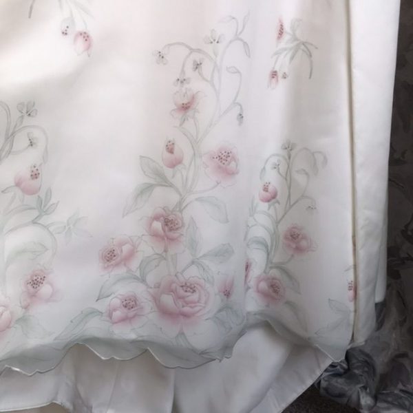 Detail of the pale pink hand painted roses on the organza skirt of the Painted Rose wedding dress