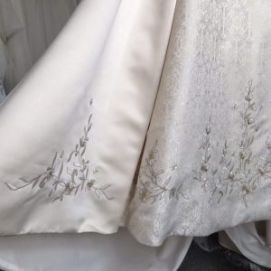 detail of the embroidery and beadwork on the brocade panel and satin skirt of the Palm Springs wedding dress